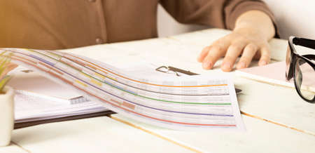 The girl writes in a notebook. A calculator, and planning. Budget planning, accounting.の写真素材