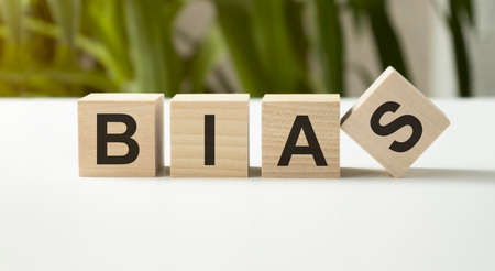 The word BIAS, spelt with wooden letter tiles over a white background.の写真素材