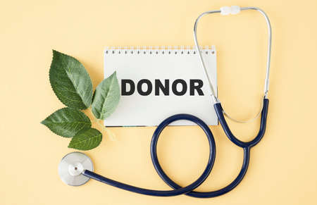 On a purple background a stethoscope with yellow list for you text DONORの写真素材