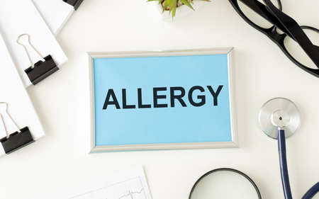 Notepad with text ALLERGY on a white background. Nearby are various medicines. Medical concept.の写真素材