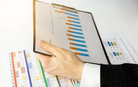 Image of male hand pointing at business document.