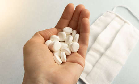 pills on the hand of man on a light backgroundの写真素材