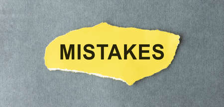 Torn paper with text COMMON MISTAKES, business concept.の写真素材
