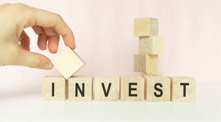 Word invest on wooden cubes, informative and communication backgroundの写真素材