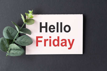 Tulips and paper with text Hello Friday on wooden tableの写真素材