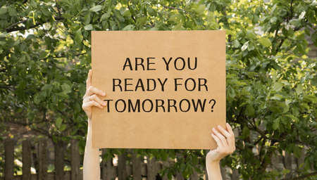 Closeup on businessman holding a card with text ARE YOU READY FOR TOMORROW, business concept image with soft focus background and vintage toneの写真素材
