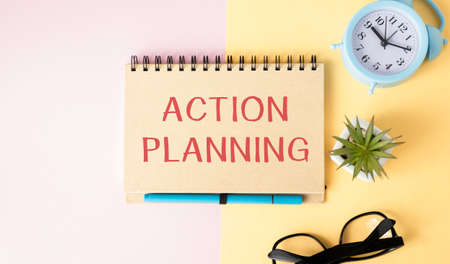 action plan text on paper with coffee and stationary on tableの写真素材