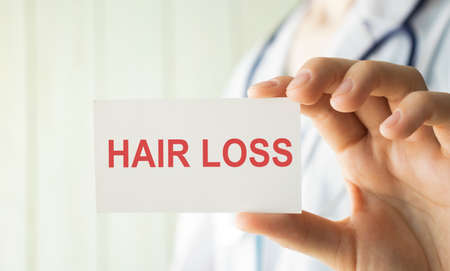 Doctor holding a card with text Hair Loss, medical concept.の写真素材