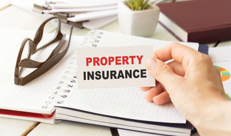 Businessman putting a card with text Renter's insurance in the pocketの写真素材