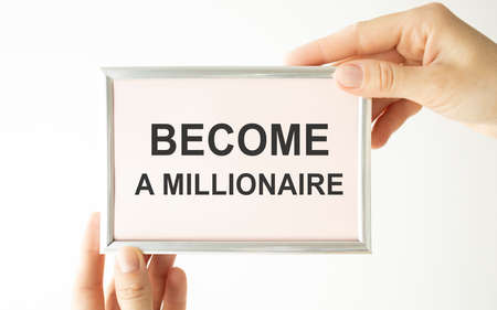 Become a Millionaire. Man holding a card with a message text written on itの写真素材