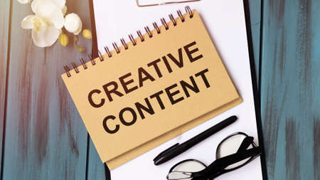 Text sign showing Creative Content. Conceptual photo providing showing with the type of content they re craving Papercraft craft paper desk square spiral notebook office study supplies.の写真素材