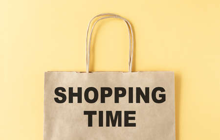 Shopping time word on paper bag isolated on yellow background.の写真素材