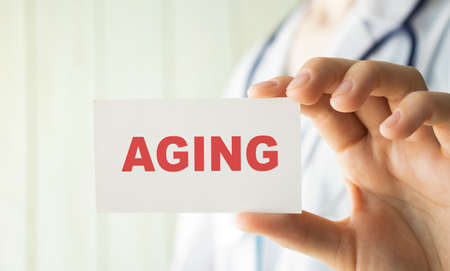 Doctor writing word Aging with marker Medical conceptの写真素材