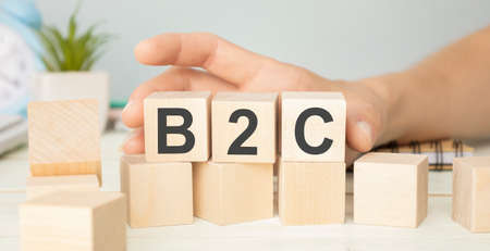 Pile with three wooden cubes - letters B2C meaning Business to customer on them, space for more text images at right side.の写真素材
