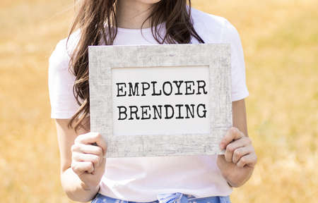 The text of the corporate identity of the employer on the card in the hands of the girl.の写真素材