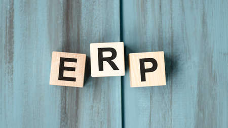 Acronym ERP- Enterprise resource planning. Wooden small cubes with letters isolated on black background with copy space available. Business Concept image.の写真素材