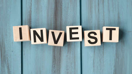 Invest word on wooden cubes. Saving and investment business financial concept.の写真素材
