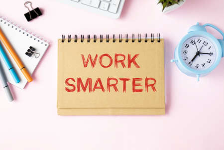 WORK SMARTER text written on a notebook with pencils and graphs.の写真素材