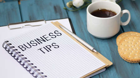 Business reports, blank paper sheet, glasses and charts - directly above view of office table workspace with FINANCIAL TIPS text.の写真素材