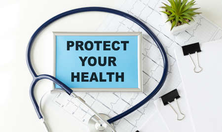 Protect your health concept. Physician shows a message on a signboard in his handsの写真素材