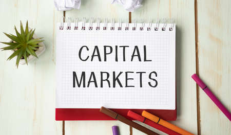 Conceptual hand writing showing Capital Market. Business photo text the venues where savings and investments are channeled Blank notebook and stationary placed above pastel colour backdrop.の写真素材