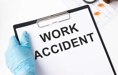 Doctor holding a card with text Work Accident, medical conceptの写真素材