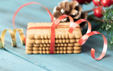 Christmas gingerbread cookies on vintage plate and anise, cinnamon, pine cones, cedar branches with golden lights on rustic table. Baked traditional gingerbread man, tree, star cookiesの写真素材