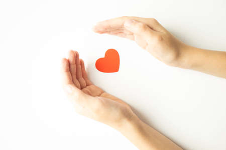 Cropped view of hand with red heart isolated on white backgroundの写真素材