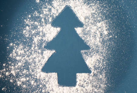 Christmas Tree Drawn on the Scattered Flour on Green Background. Minimal Holiday Concept.の写真素材