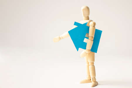 Blue paper house in the hands of a wooden man, real estate insurance conceptの写真素材