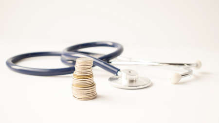 Stethoscope on coin stack, on white background. money for health care, Financial Aid, concept.の写真素材
