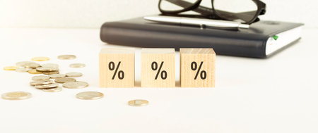Businessman working and writing on notebook with stack of coins for financial and accounting...