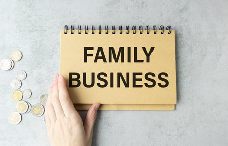 Card with text FAMILY BUSINESS on old wooden table outdoors, top view. Business model concept.の写真素材