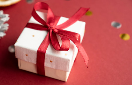 Cardboard gift box with bow on red background.の写真素材