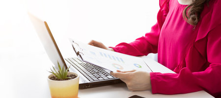 Young woman using calculator, calculating finance at workplace, female hands and paper document at...