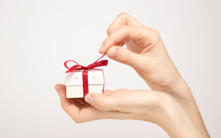 Female hands holding a luxury small gift box. isolated on white background. Christmas and New Year's day. Mock up template ready for your design.の写真素材