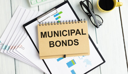 On the table are financial reports, a pen, a magnifying glass and a notebook with the inscription - Municipal bonds. Business and finance concept.の写真素材
