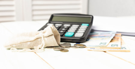Calculator, Eyeglasses And Coins On Office Tableの写真素材