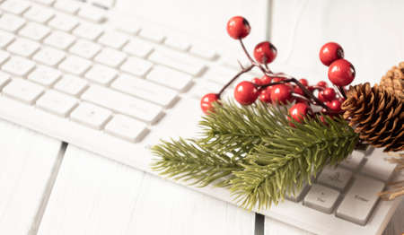 Christmas beautiful red balls with fir branch and snow on computer keyboard.の写真素材