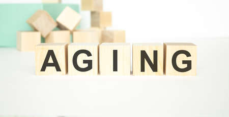 Ageing - word from wooden blocks with letters, growing old senescence aging concept, random letters...