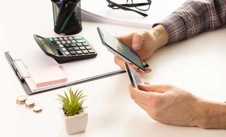 Man hands using smartphone and laptop computer for online shopping at home, Hand holding mobile...