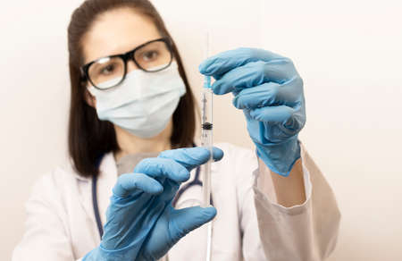 Doctor Hand In Blue Nitrile Gloves Holding Flu, Measles, Coronavirus Vaccine. Covid-19 Virus, Coronaの写真素材