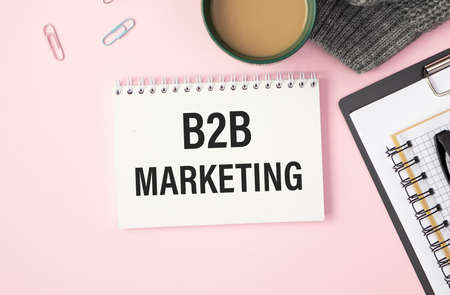 Office desk and notebook with text - B2B marketing, keyboard and a cup of teaの写真素材
