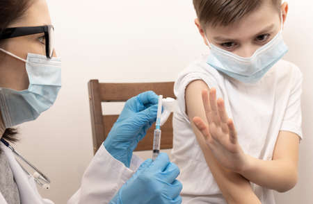 Portrait of adorable little boy being vaccinate at doctor's officeの写真素材
