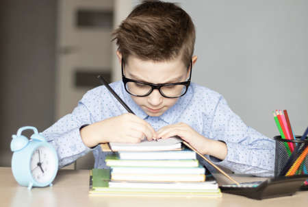 Cute little boy doing homework. Child learning foe school.の写真素材