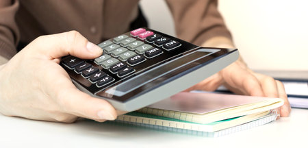 Close up asian business woman using a calculator to calculate the numbers. Business finances and...