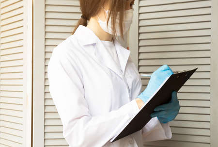 The doctor in a white coat makes notes.の写真素材