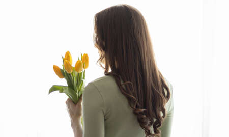 Women's hands are holding a bouquet of tulipsの写真素材