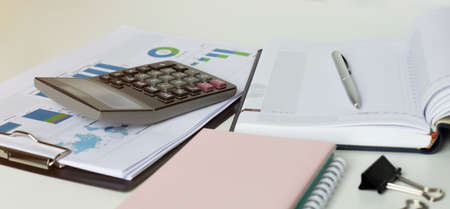 pen on a notebook into a cell and calculator close up