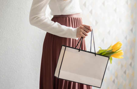 Text Spring sale on the lightbox with present bag and beautiful flowers on pastel background. Festive sale and promo banner.の写真素材